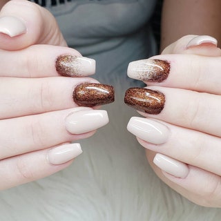 A sparkly manicure with cream polish and brown shimmery ombre accents