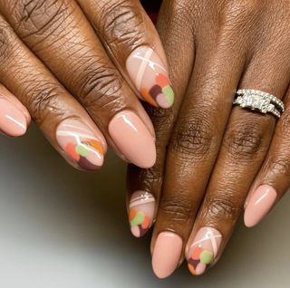 Nudecolored manicured nails with various colors at the tips