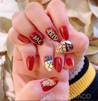 Manicured nails with red nail polish and illustrations of Garfield