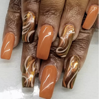 Manicured hand featuring orangepainted nails with curvy lines