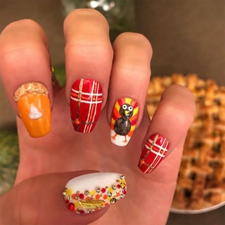 Manicured hand featuring illustrations of a pumpkin pie a turkey multicolored beads and a plaid pattern.
